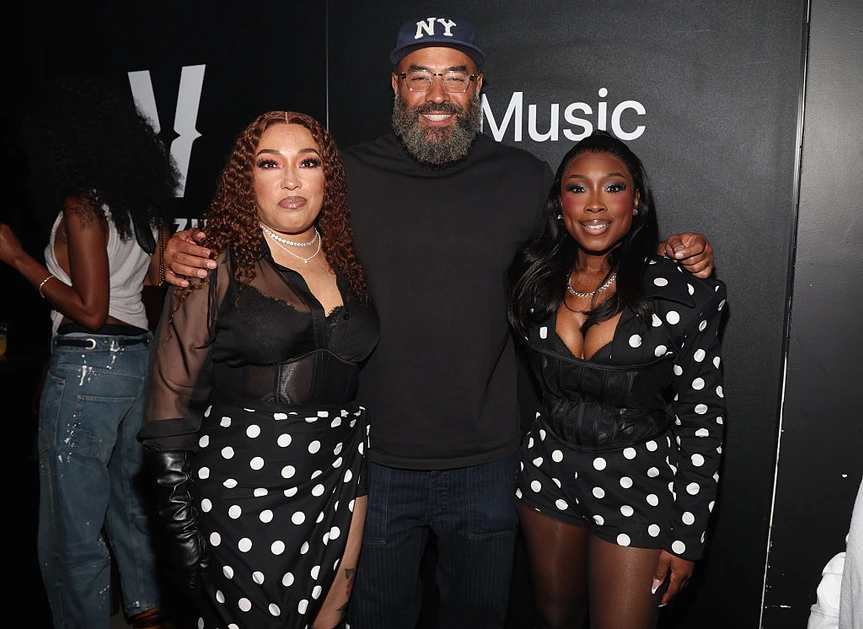 Misha Grinstead and Meelah Williams of 702 pose with Ebro Darden.
