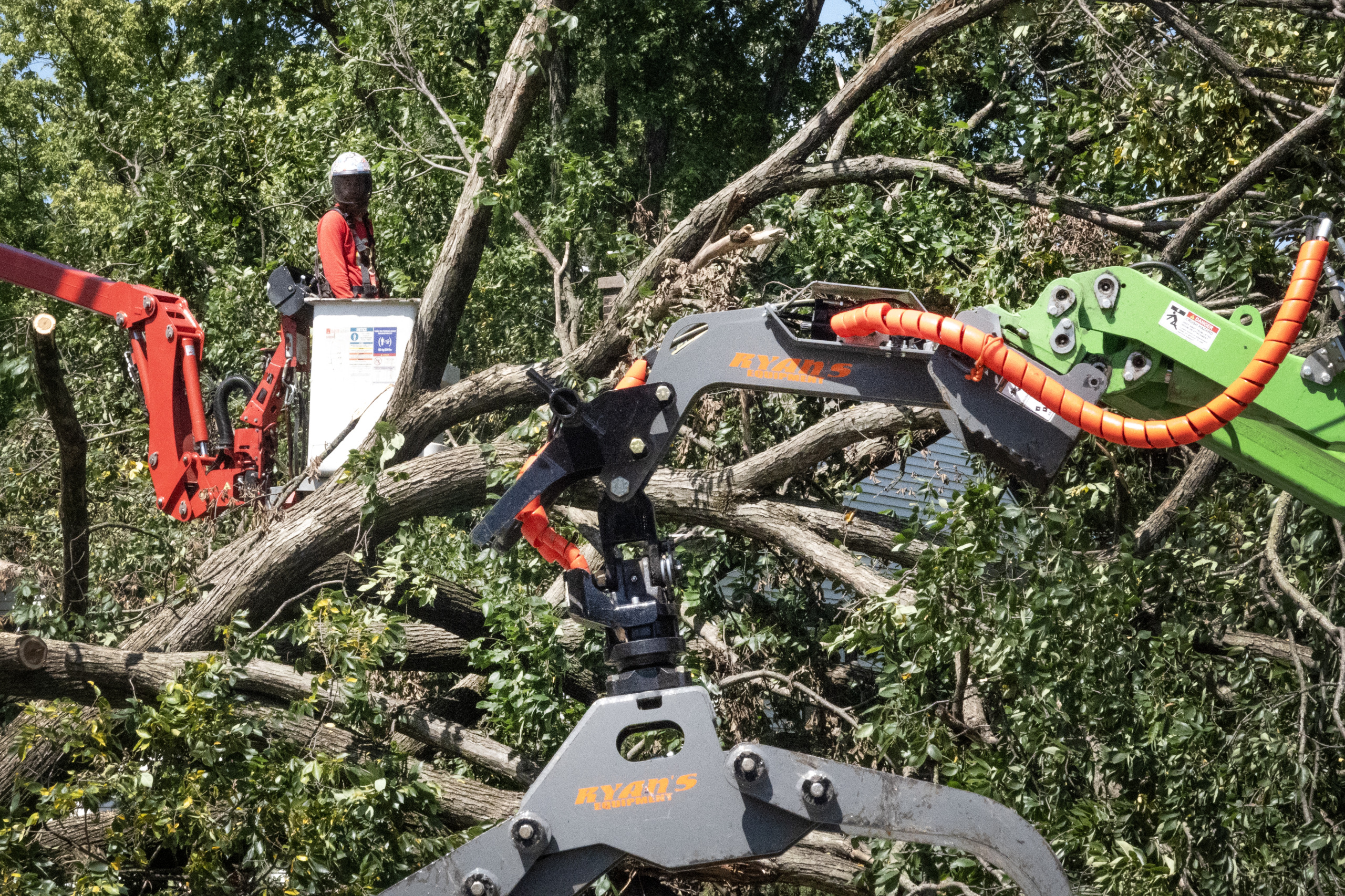 Workers remove a tree from the front of a home after it was toppled during a recent storm in Gary, Indiana.(Photo by Scott Olson/Getty Images)