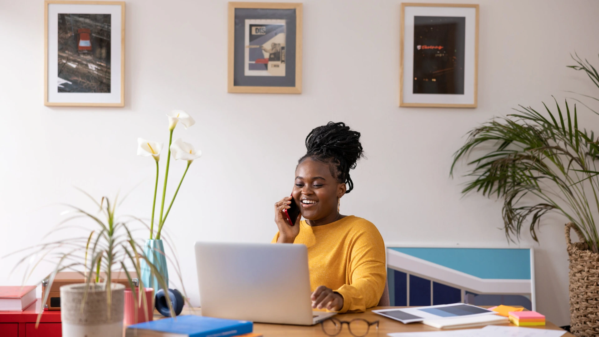Young African American woman talking on her smart phone and working at home