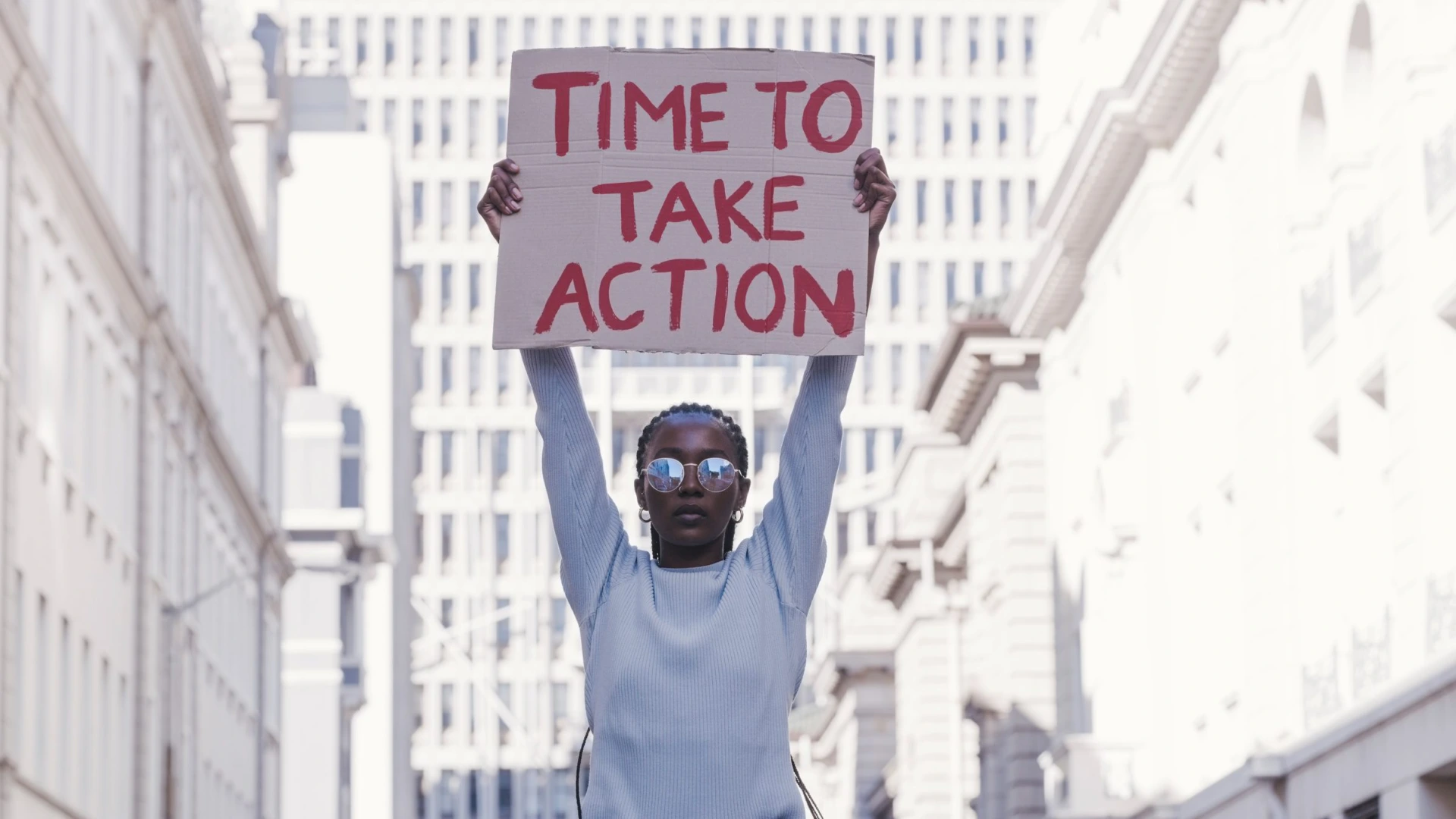 Protest, city and cardboard in black woman hands for equality, Justice and human rights with vote for government action, change and revolution. Urban girl in street with poster for politics activism
