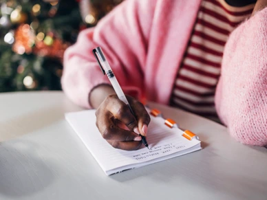 Woman Writing New Year’s Resolutions