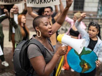 Mid adult woman leading a demonstration using a megaphone