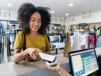 Woman making a mobile payment at a clothing store