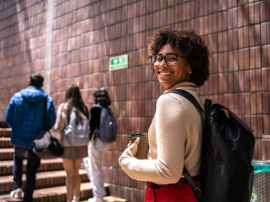Portrait of a young student woman walking up the stairs