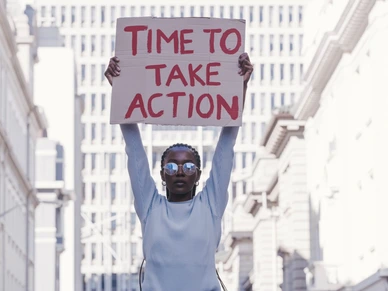 Protest, city and cardboard in black woman hands for equality, Justice and human rights with vote for government action, change and revolution. Urban girl in street with poster for politics activism