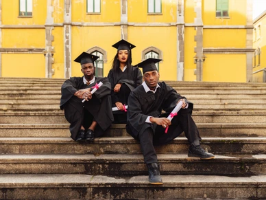 Young black students celebrating graduation day at university campus